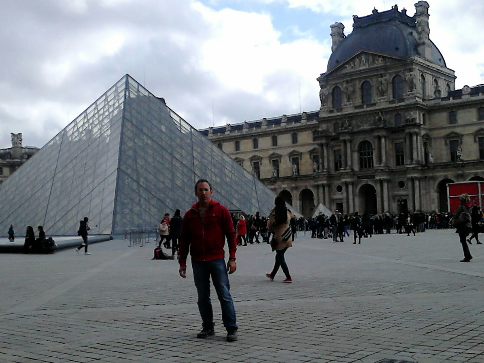Ángel delante de una de las pirámides del Louvre en París.